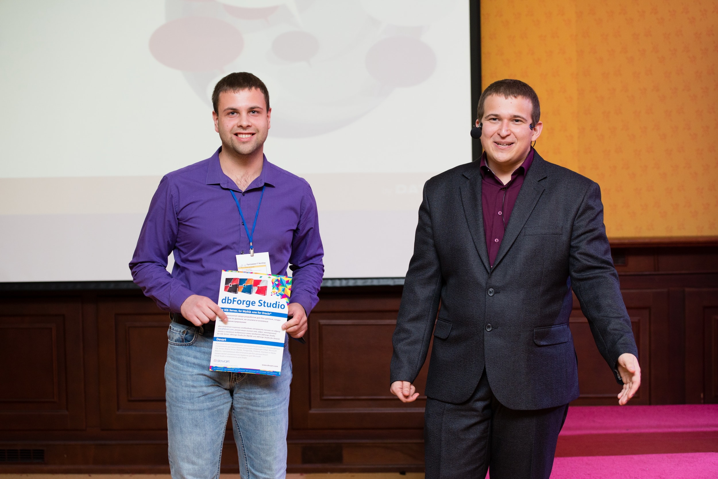 The speaker presents a conference participant with a certificate for dbForge Studio